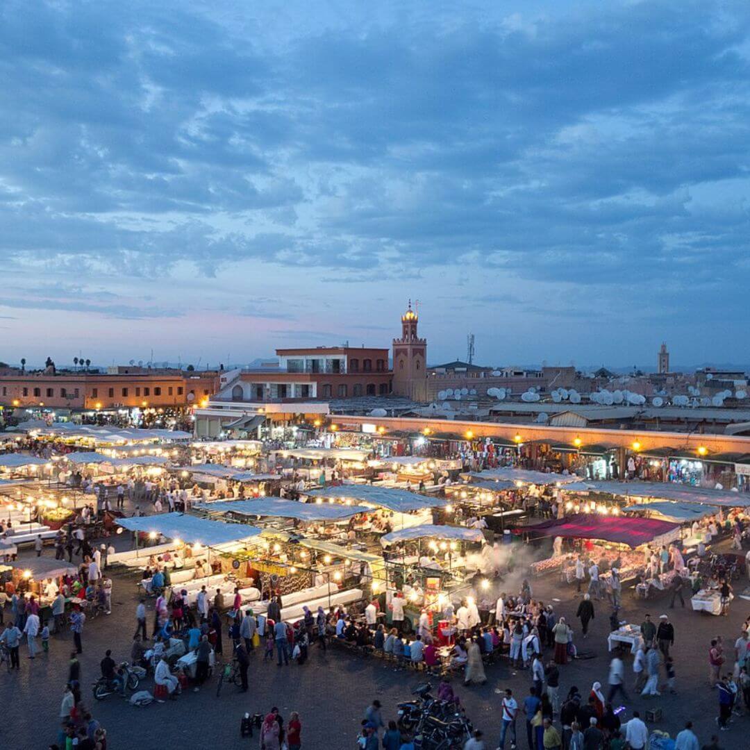 Guided Tour Marrakech Vibrant street performers and food stalls in Jemaa el-Fnaa Square, Marrakech